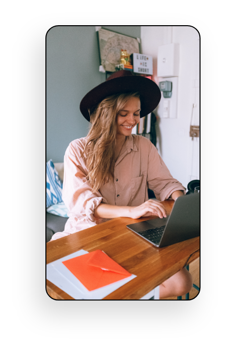 O imagine cu o domnișoară care scrie pe laptop și zâmbește.